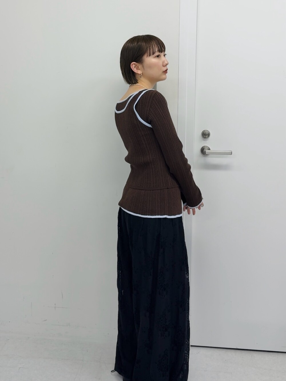 ブラウン系のニット/セーター、ブラック系のその他パンツを着用したレディースの冬コーディネートの2枚目の写真