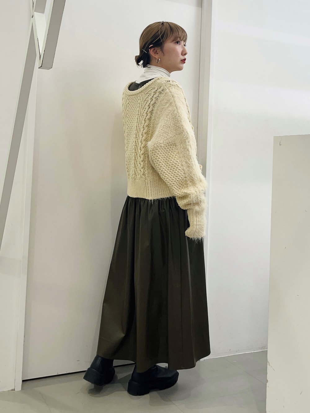 ホワイト系のニット/セーター、ブラウン系のワンピース、ブラック系のブーツを着用したレディースの冬コーディネートの4枚目の写真