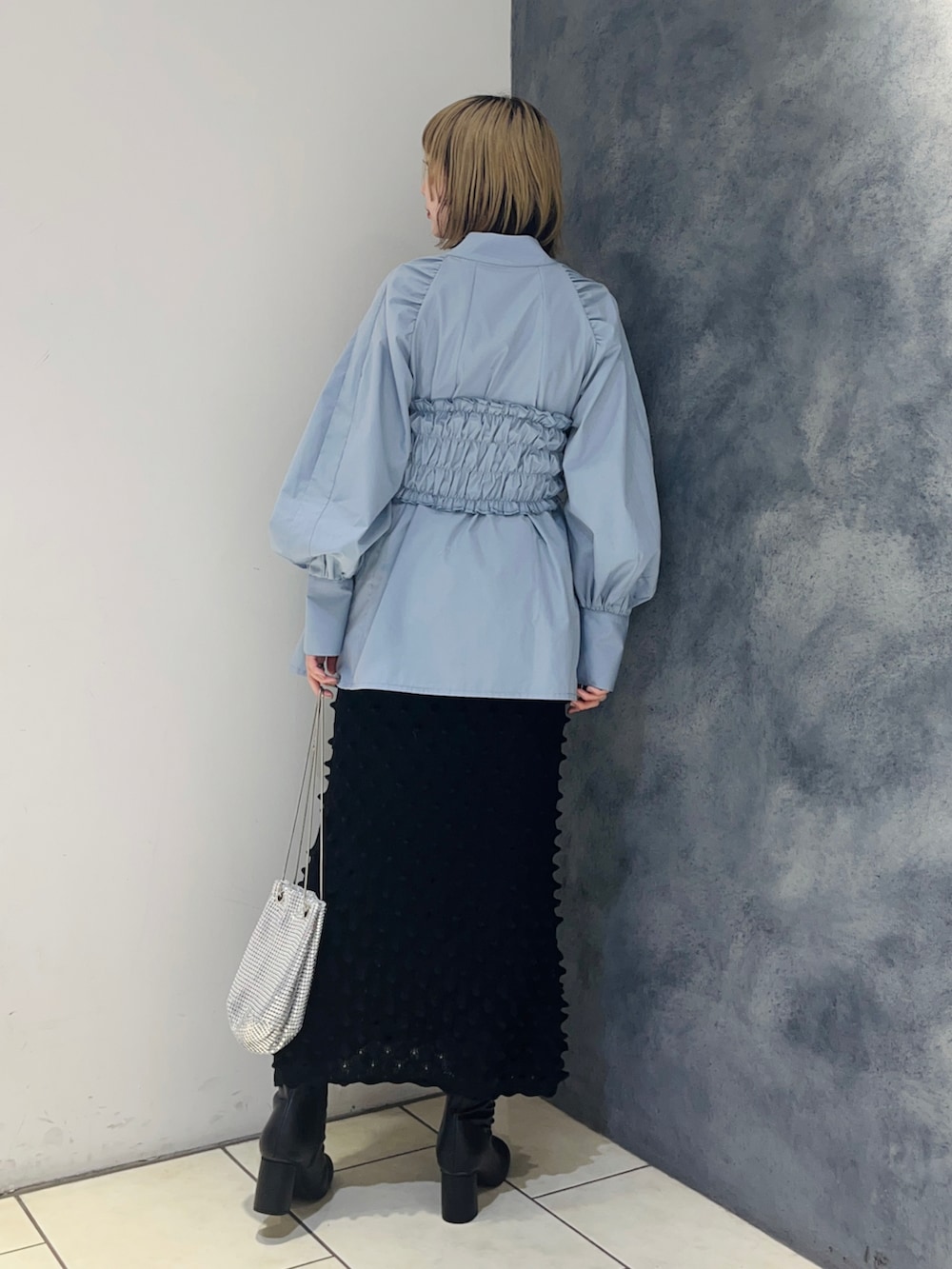 ブルー系のシャツ/ブラウス、ブラック系のスカート、ブラック系のブーツを着用したレディースの冬コーディネートの4枚目の写真