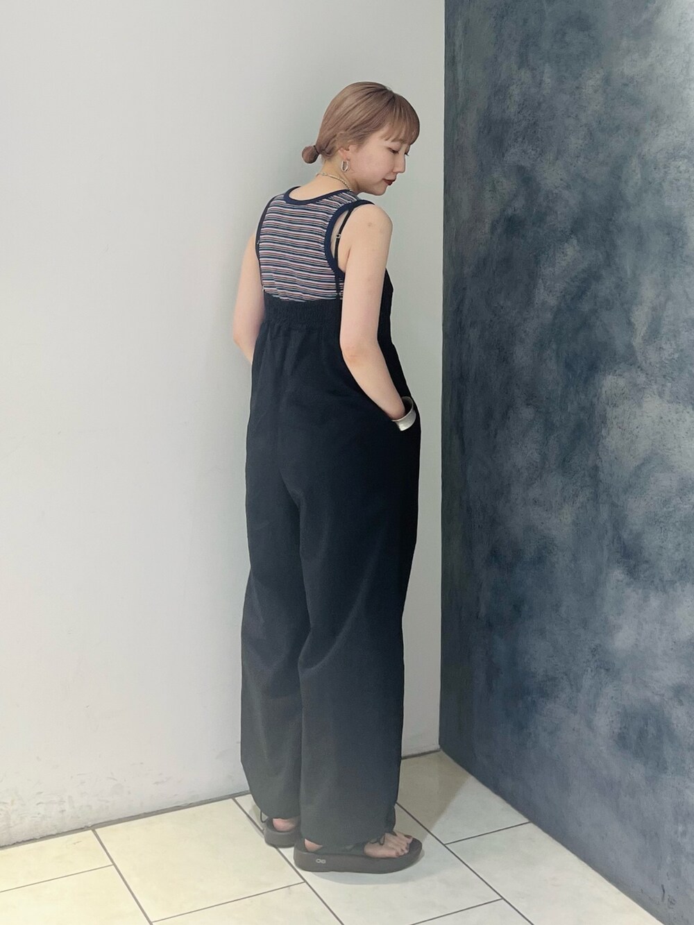 ブルー系のタンクトップ、ブラック系のサロペット/オーバーオール、シルバー系のネックレスを着用したレディースの夏コーディネートの4枚目の写真