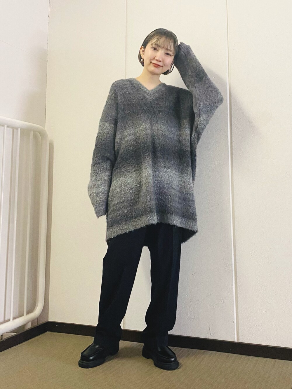 ブラック系のニット/セーター、ベージュ系のその他パンツ、ブラック系のブーツを着用したレディースの秋コーディネートの2枚目の写真