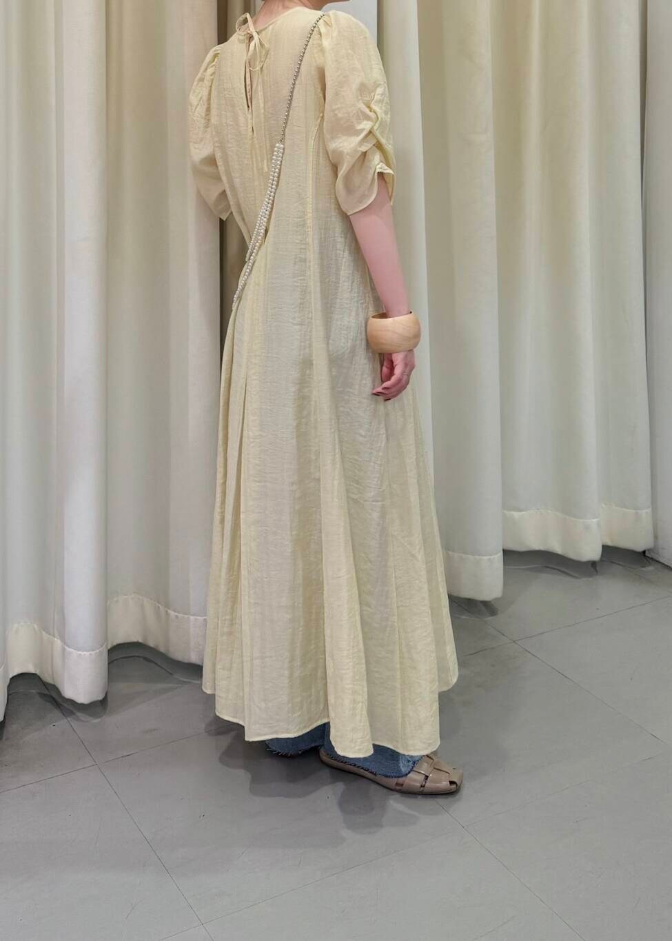 ブルー系のデニムパンツ、シルバー系のネックレス、ベージュ系のブレスレットを着用したレディースの春コーディネートの3枚目の写真