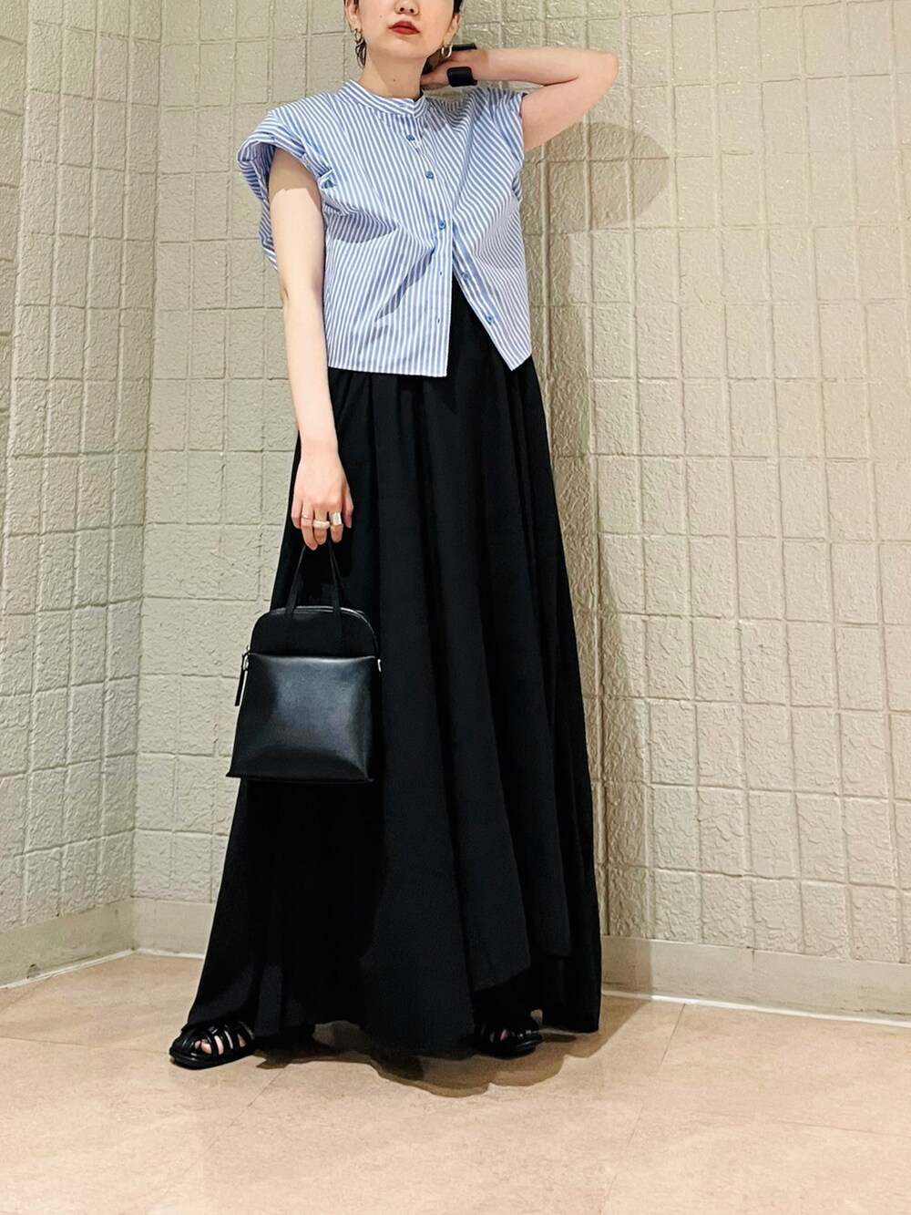 ブルー系のシャツ/ブラウス、ブラック系のワンピース、ブラック系のハンドバッグを着用したレディースの夏コーディネートの2枚目の写真