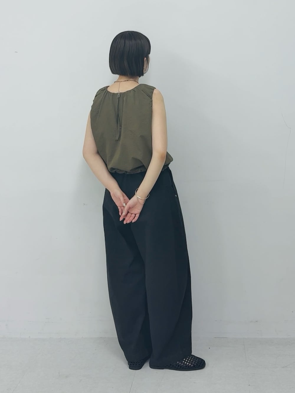 グリーン系のシャツ/ブラウス、グレー系のその他パンツ、ブラック系のサンダルを着用したレディースの夏コーディネートの2枚目の写真