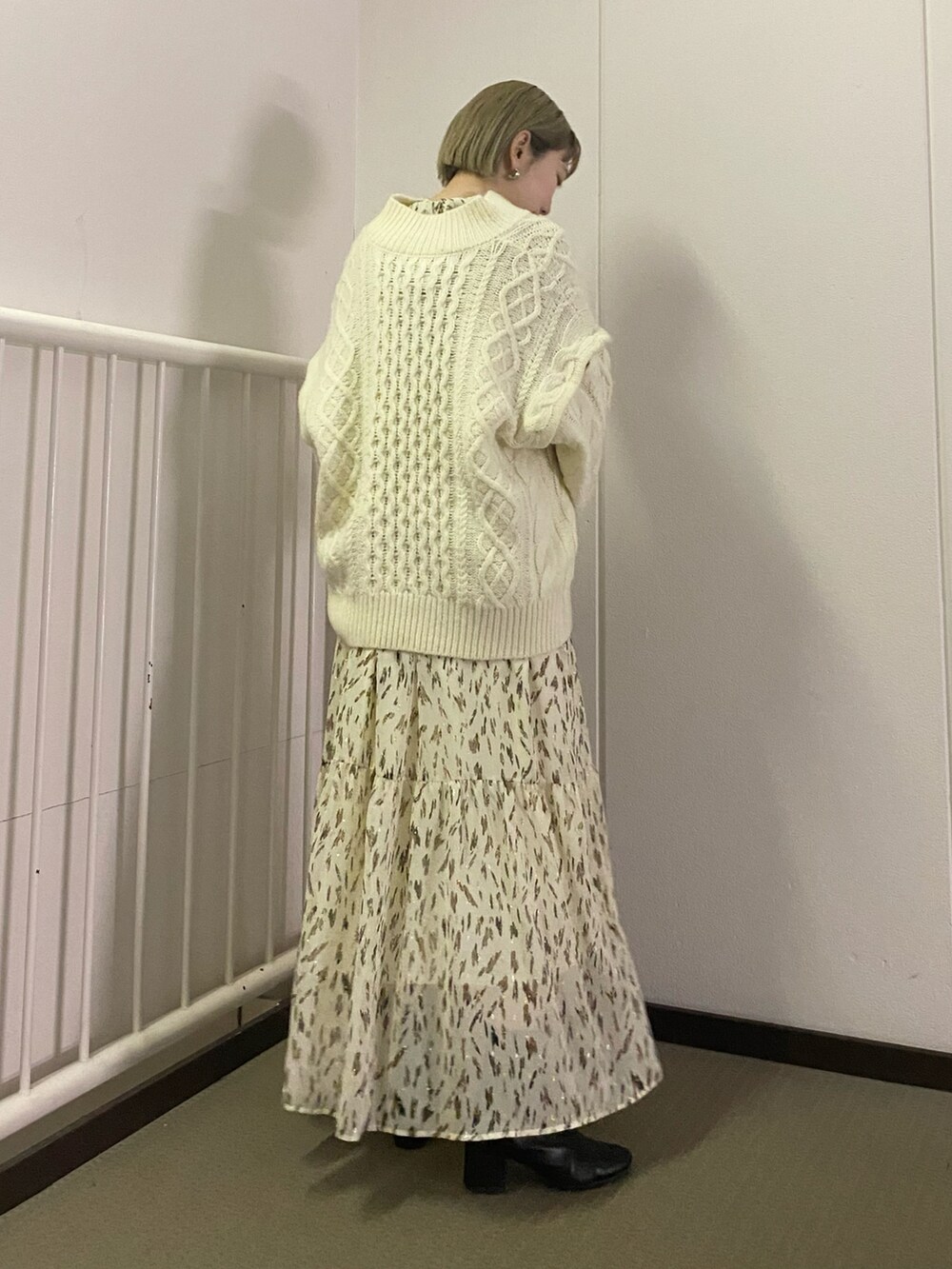 ホワイト系のニット/セーター、ホワイト系のワンピースを着用したレディースの冬コーディネートの2枚目の写真