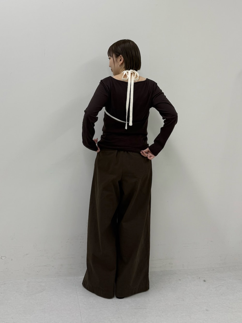 ブラウン系のTシャツ/カットソー、ホワイト系のキーホルダーを着用したレディースの冬コーディネートの3枚目の写真