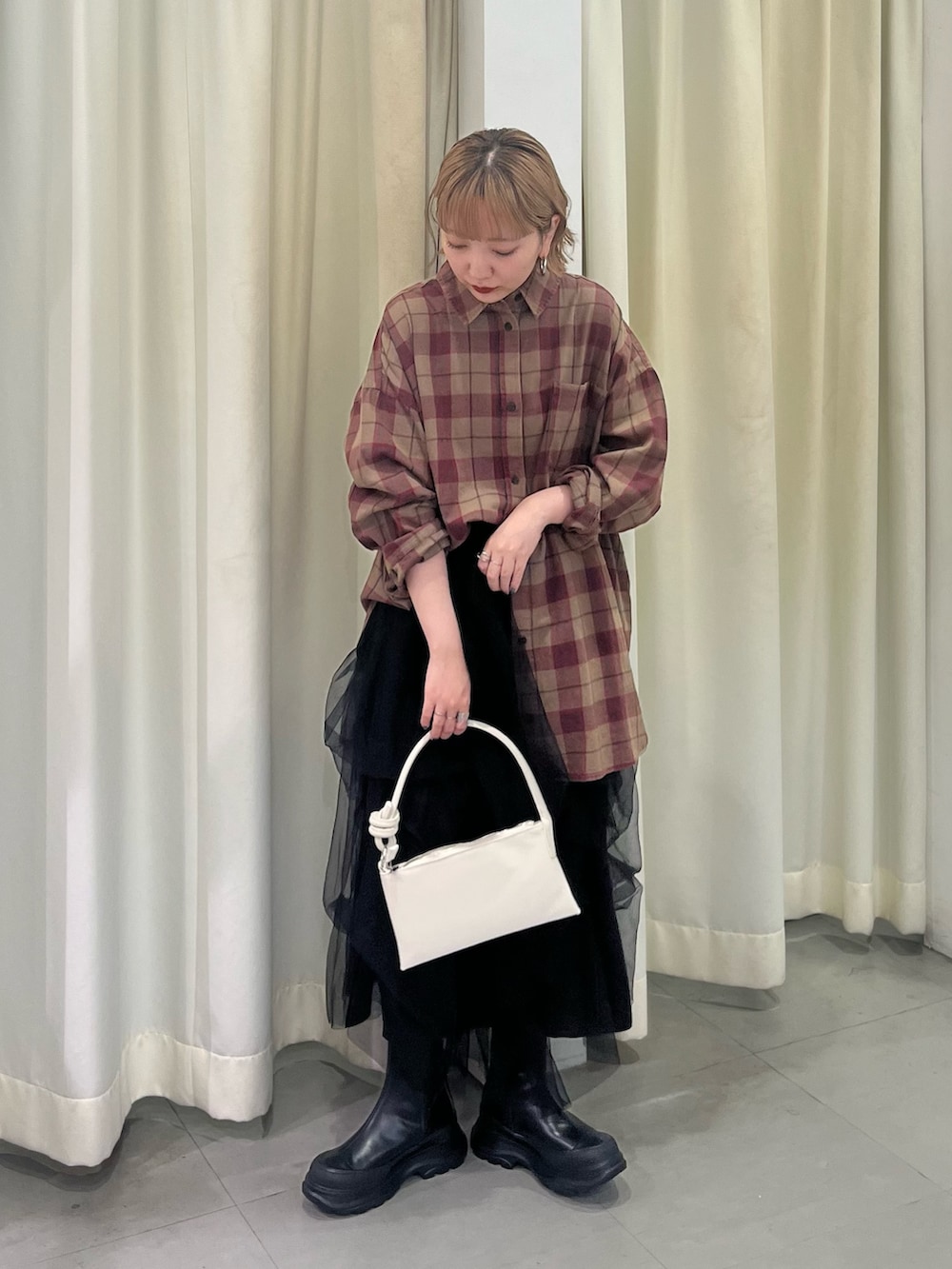 ブラウン系のシャツ/ブラウス、ブラック系のスカート、ブラック系のブーツを着用したレディースの秋コーディネートの2枚目の写真