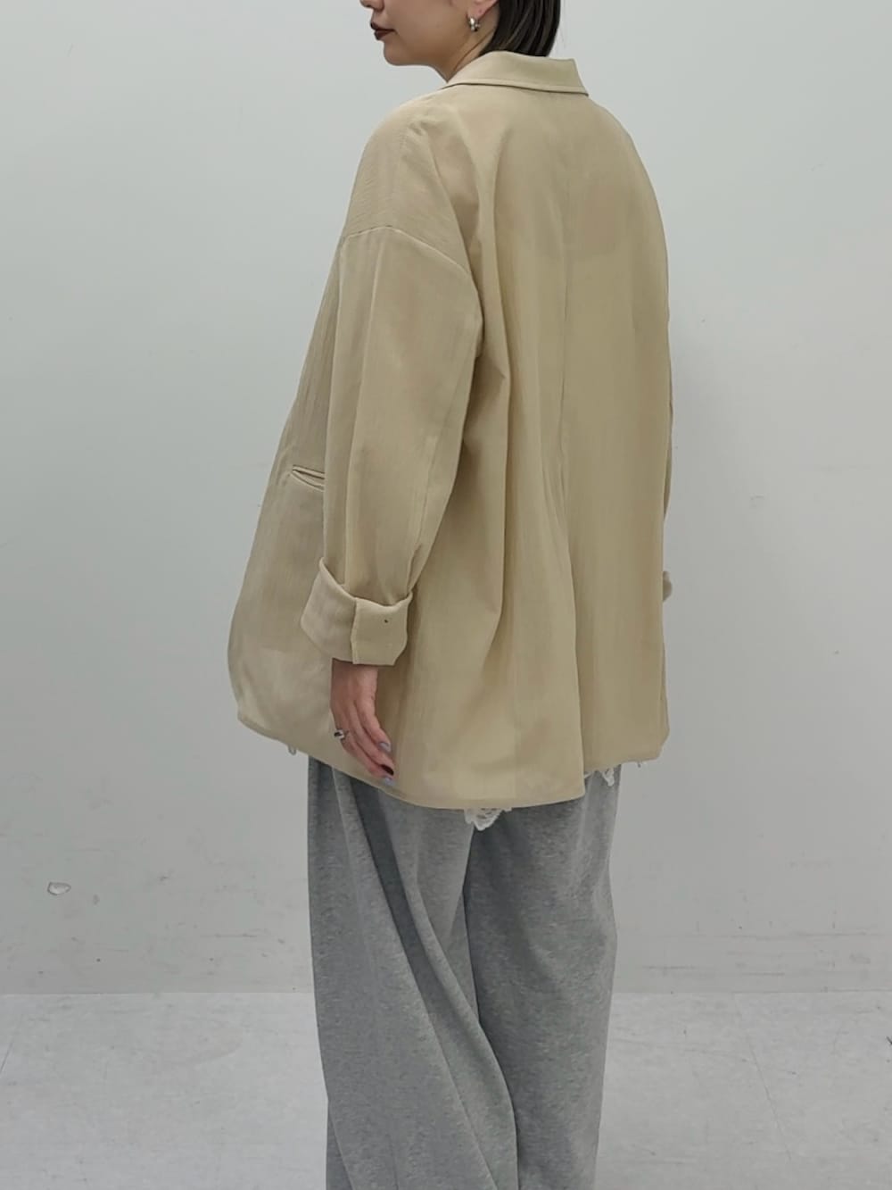 ベージュ系のその他アウター、ホワイト系のキャミソール、グレー系のその他パンツを着用したレディースの春コーディネートの3枚目の写真