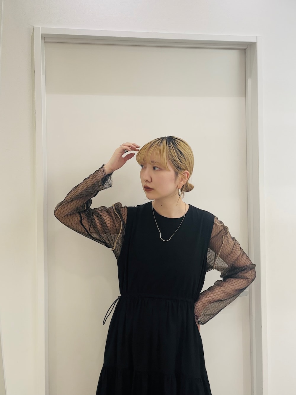 ブラック系のワンピース、ブラック系のニット/セーター、ブラック系のサンダルを着用したレディースの春コーディネートの4枚目の写真