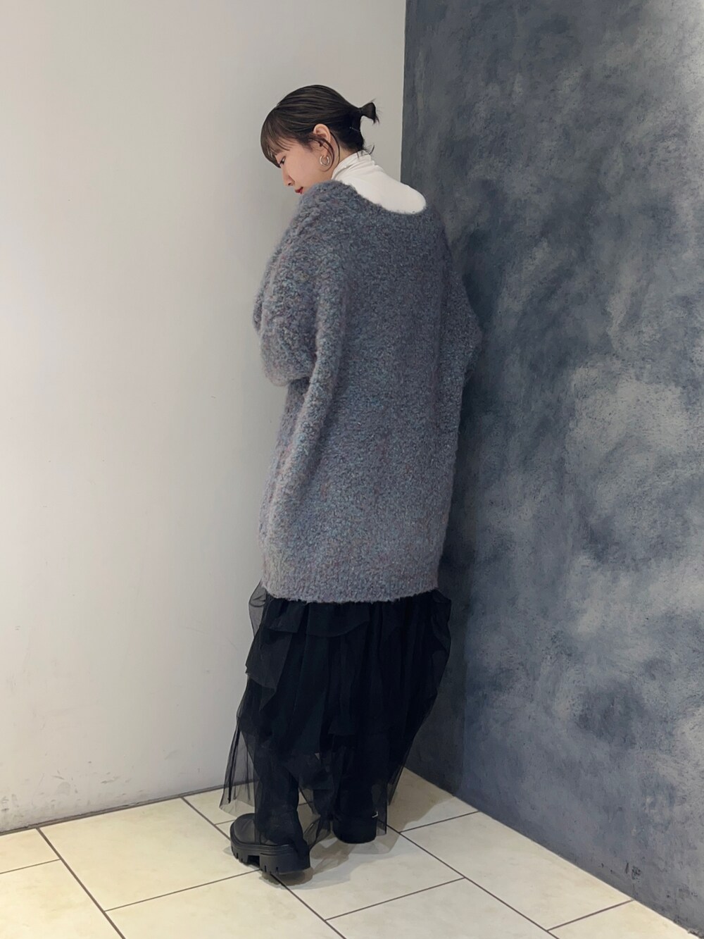 ブルー系のカーディガン/ボレロ、ブラック系のスカート、ホワイト系のTシャツ/カットソーを着用したレディースの秋コーディネートの4枚目の写真