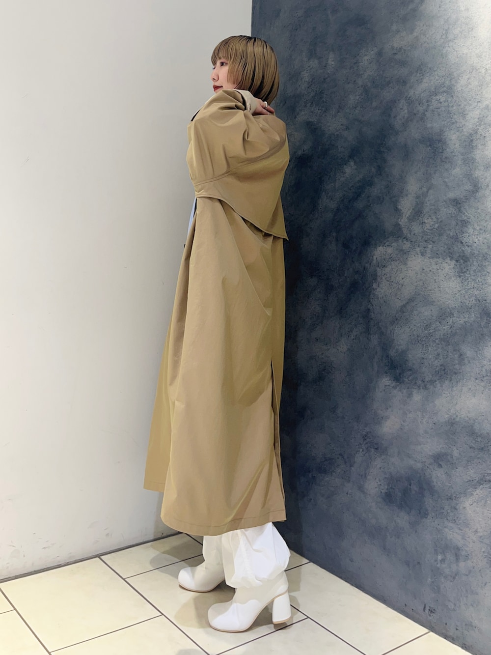 ブルー系のシャツ/ブラウス、ベージュ系のステンカラーコート、ホワイト系のその他パンツを着用したレディースの冬コーディネートの3枚目の写真