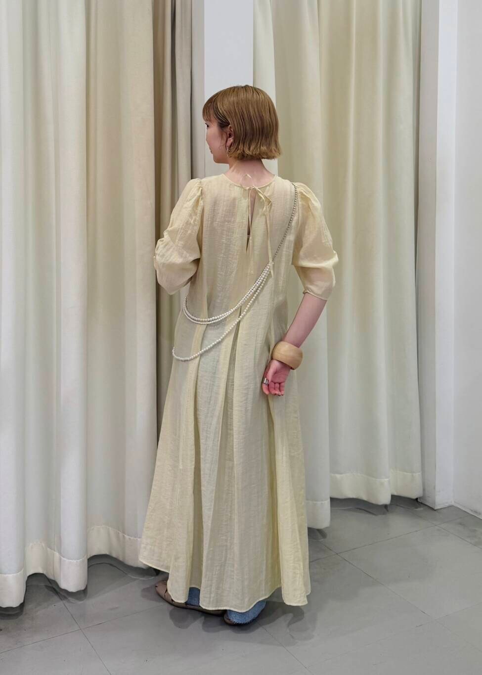 ブルー系のデニムパンツ、シルバー系のネックレス、ベージュ系のブレスレットを着用したレディースの春コーディネートの2枚目の写真