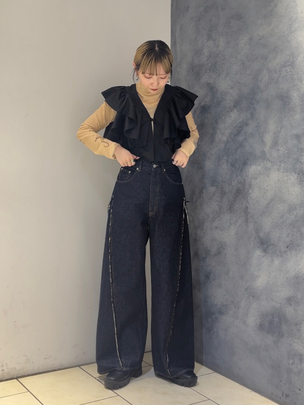 ブラック系のシャツ/ブラウス、ベージュ系のTシャツ/カットソー、ブルー系のデニムパンツを着用したレディースの春コーディネートの2枚目の写真