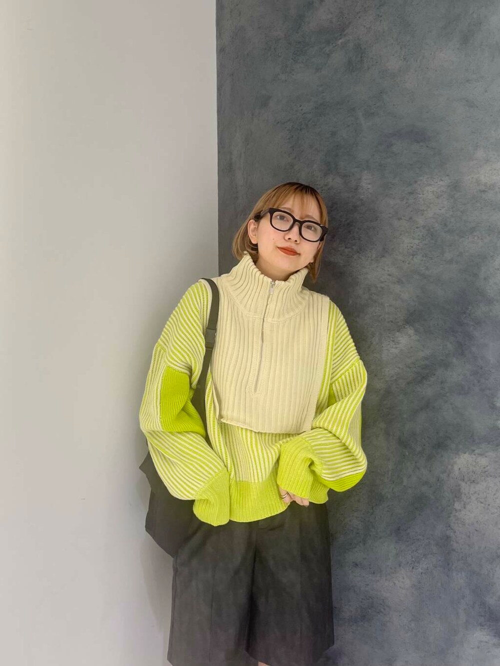 グリーン系のニット/セーター、グレー系のその他パンツ、ブラック系のショルダーバッグを着用したレディースの秋コーディネートの2枚目の写真