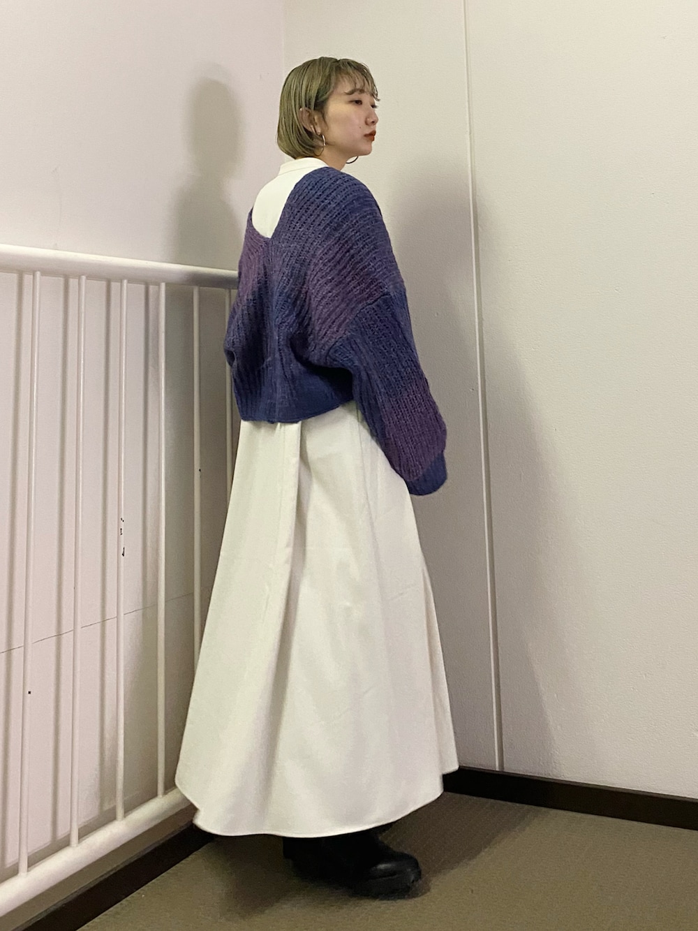 グリーン系のワンピース、パープル系のカーディガン/ボレロを着用したレディースの秋コーディネートの5枚目の写真