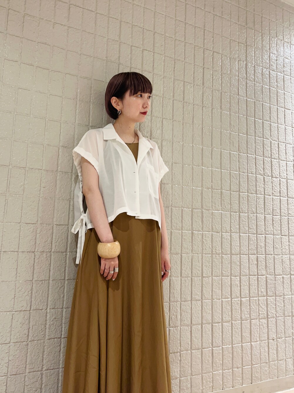 ホワイト系のシャツ/ブラウス、イエロー系のワンピース、ゴールド系のサンダルを着用したレディースの夏コーディネートの5枚目の写真