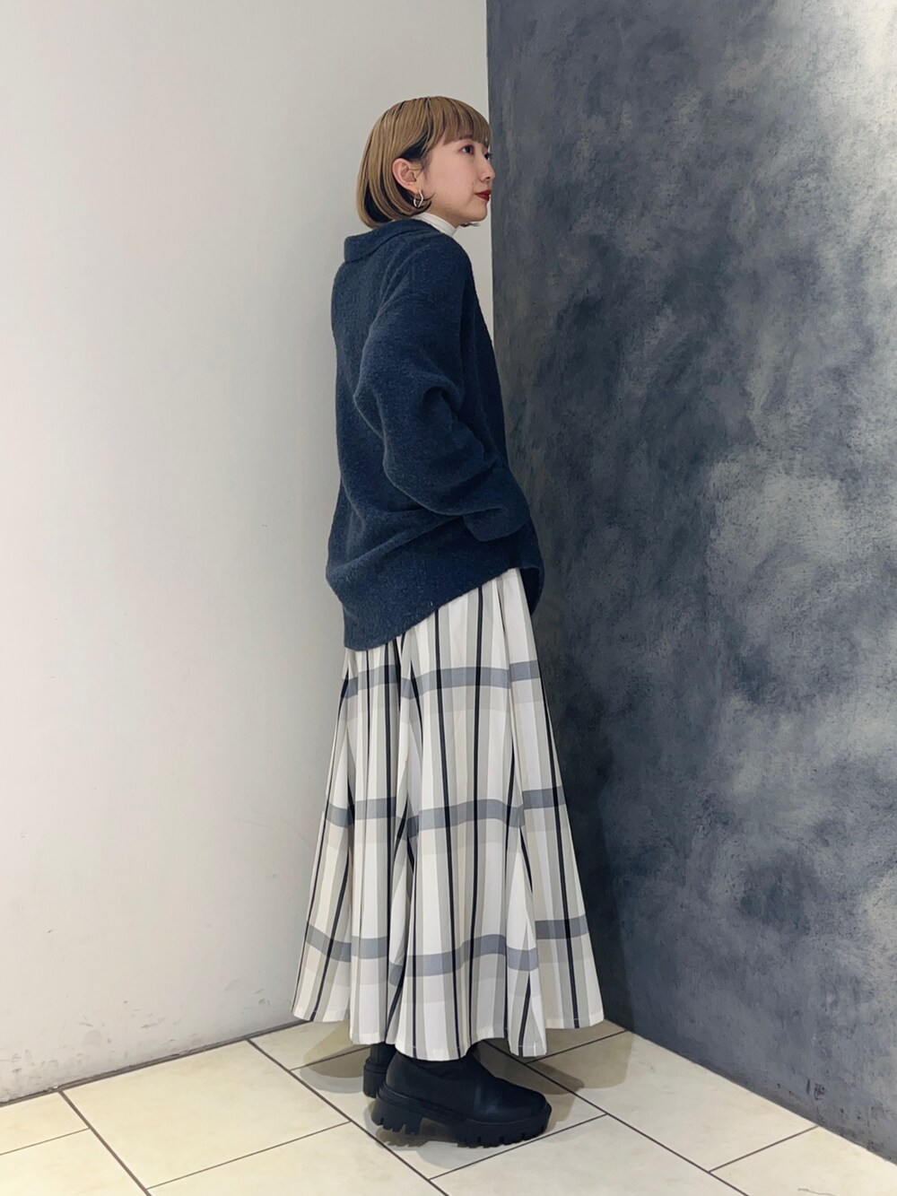 ブルー系のニット/セーター、ホワイト系のスカート、ホワイト系のTシャツ/カットソーを着用したレディースの冬コーディネートの3枚目の写真