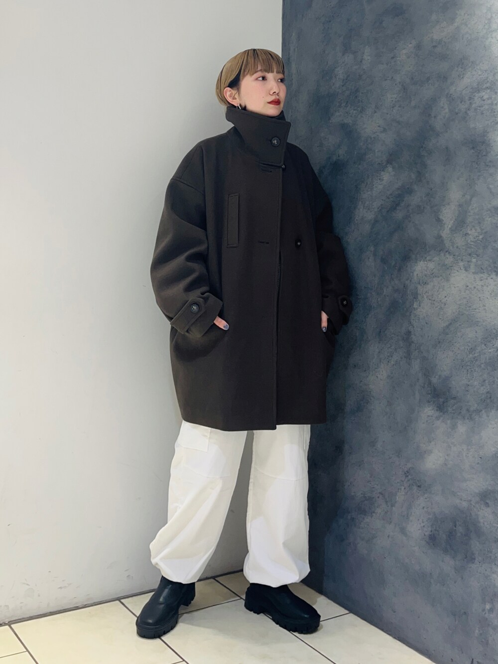 ブラウン系のその他アウター、ブルー系のニット/セーター、ホワイト系のカーゴパンツを着用したレディースの冬コーディネートの2枚目の写真