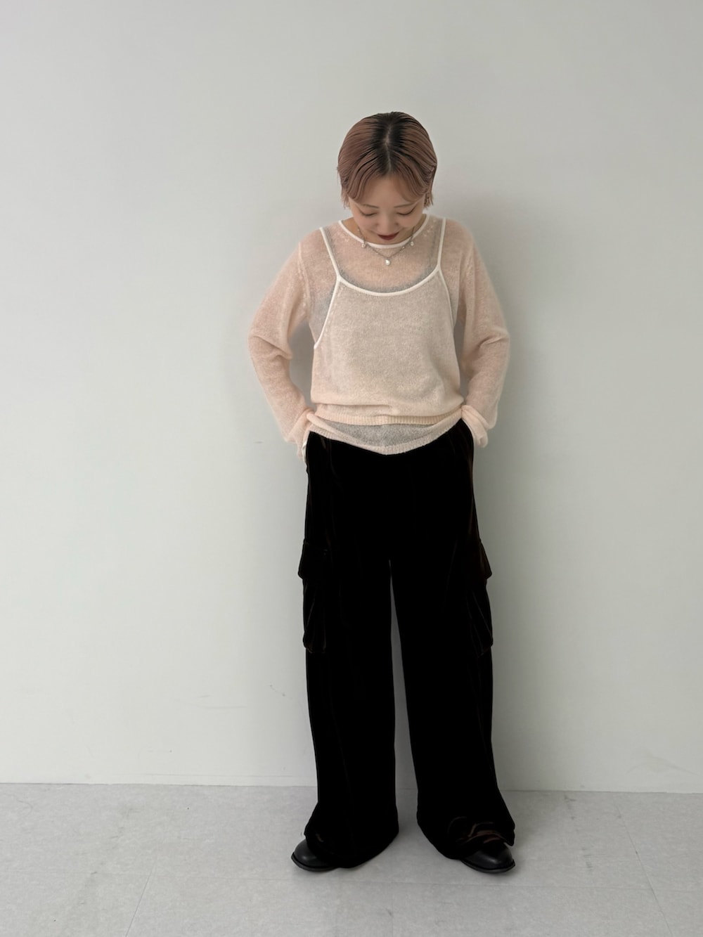 ピンク系のニット/セーター、ブラウン系のその他パンツを着用したレディースの秋コーディネートの3枚目の写真