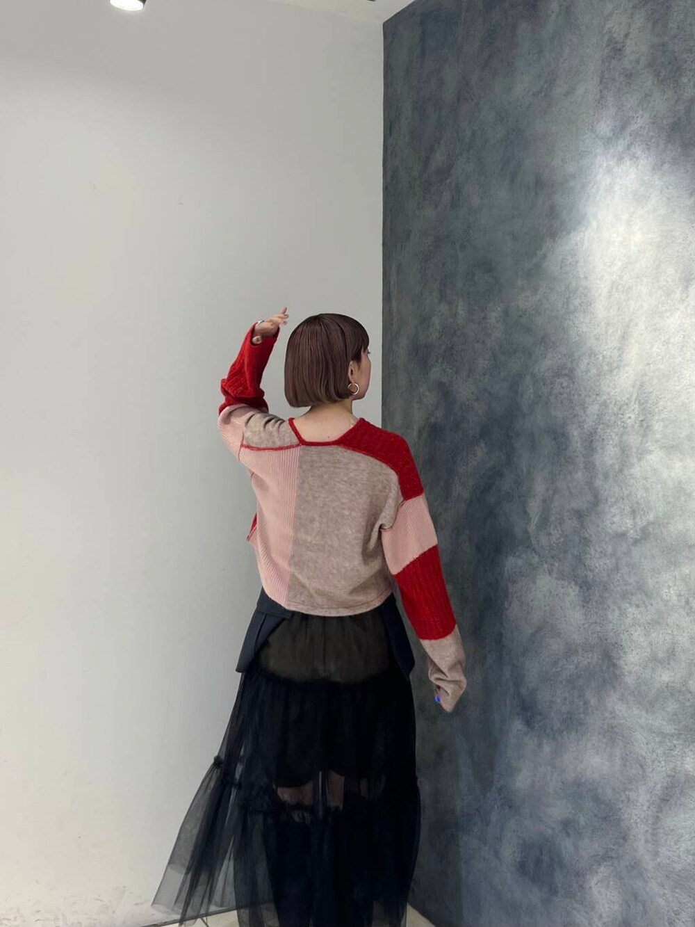 グレー系のスカート、ブラウン系のその他パンツ、レッド系のニット/セーターを着用したレディースの夏コーディネートの4枚目の写真