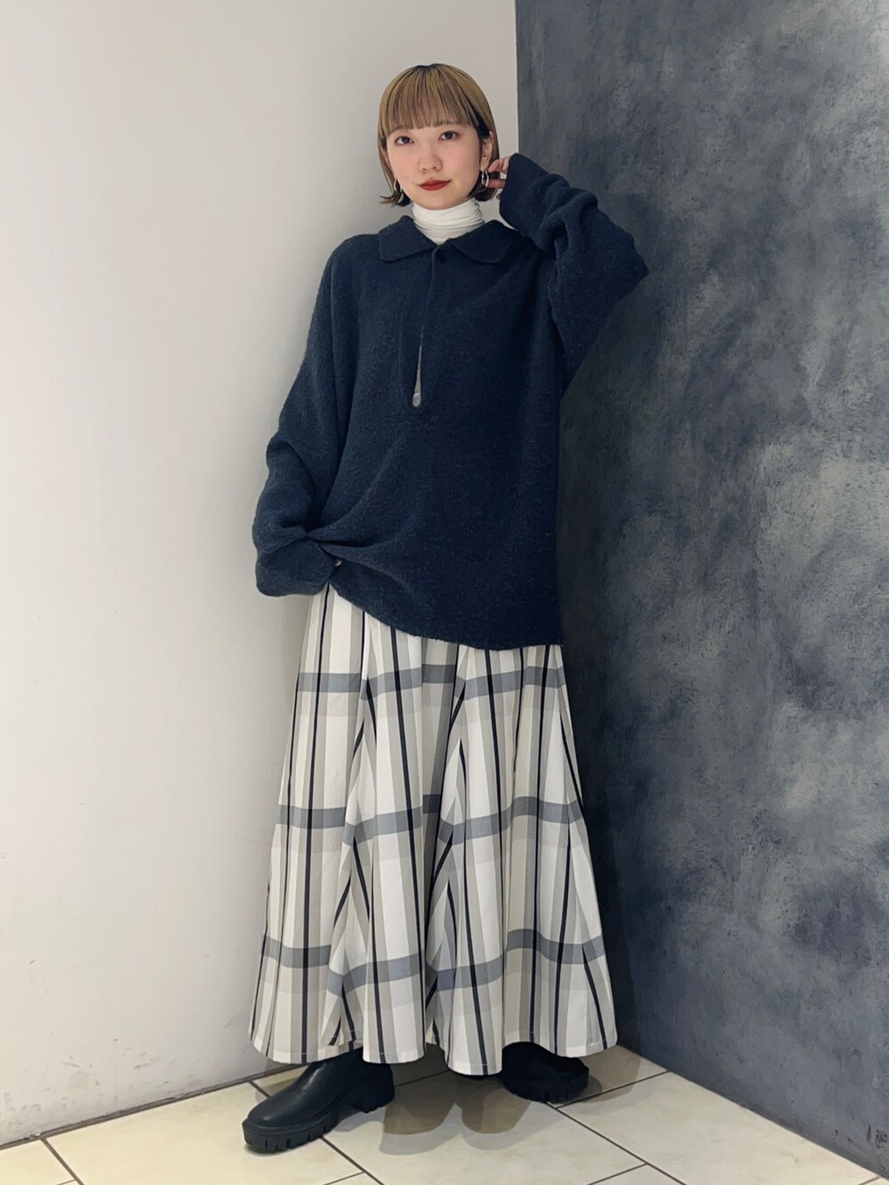 ブルー系のニット/セーター、ホワイト系のスカート、ホワイト系のTシャツ/カットソーを着用したレディースの冬コーディネートの2枚目の写真