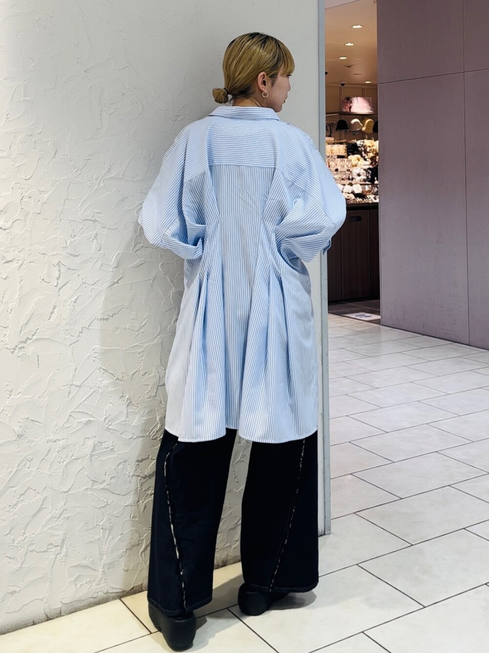 ブルー系のワンピース、ブラック系のTシャツ/カットソー、ブルー系のデニムパンツを着用したレディースの春コーディネートの2枚目の写真