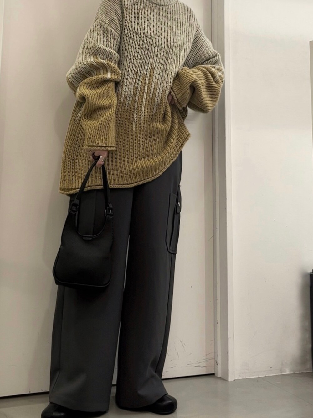 グレー系のニット/セーター、グレー系のその他パンツ、ブラック系のハンドバッグを着用したレディースの冬コーディネートの4枚目の写真