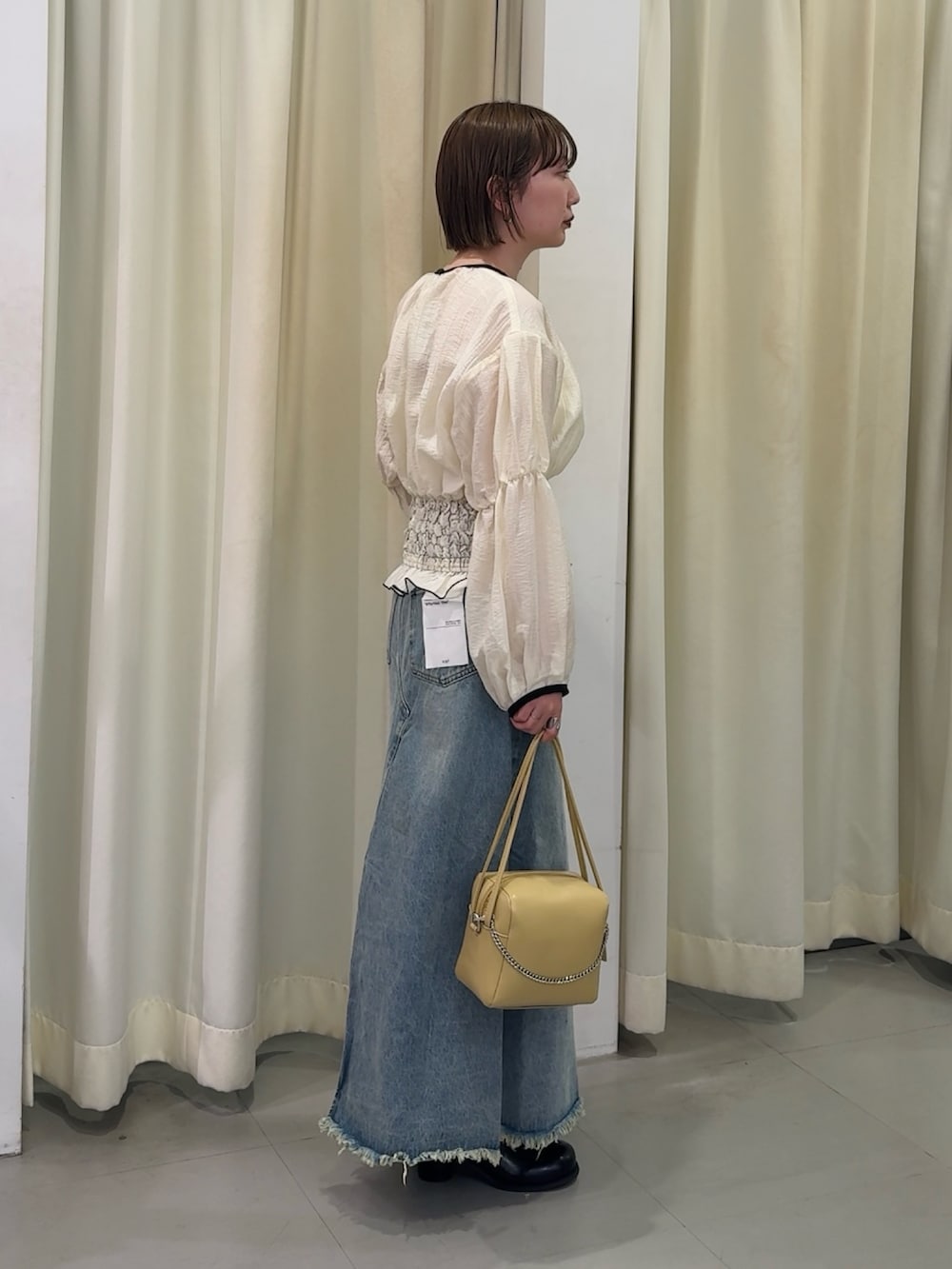 ホワイト系のシャツ/ブラウス、ブルー系のスカート、ベージュ系のショルダーバッグを着用したレディースの春コーディネートの3枚目の写真