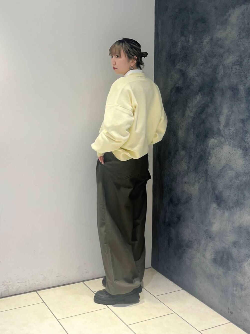 グリーン系のその他パンツ、ホワイト系のシャツ/ブラウス、イエロー系のニット/セーターを着用したレディースの冬コーディネートの3枚目の写真