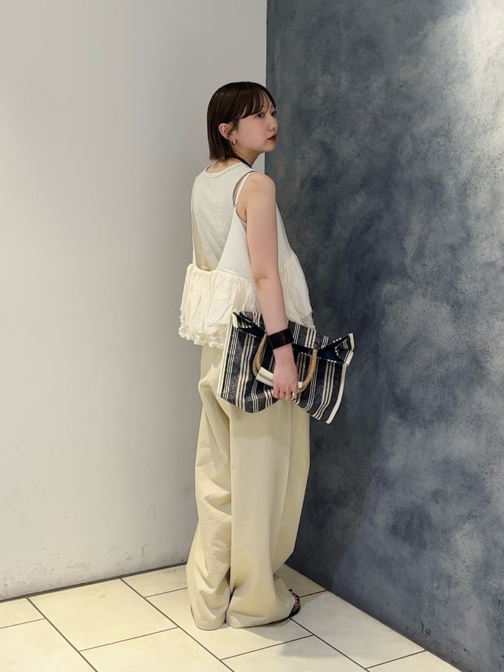 ベージュ系のその他パンツ、ホワイト系のトートバッグ、ブラウン系のサンダルを着用したレディースの夏コーディネートの2枚目の写真