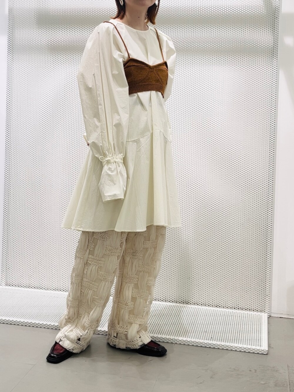 ホワイト系のワンピース、ブラウン系のベスト、ホワイト系のその他パンツを着用したレディースの春コーディネートの3枚目の写真