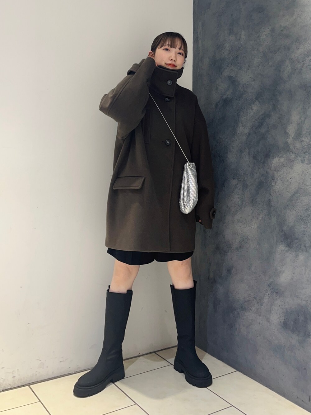 ブラウン系のその他アウター、ブラック系のブーツ、シルバー系のショルダーバッグを着用したレディースの秋コーディネートの2枚目の写真