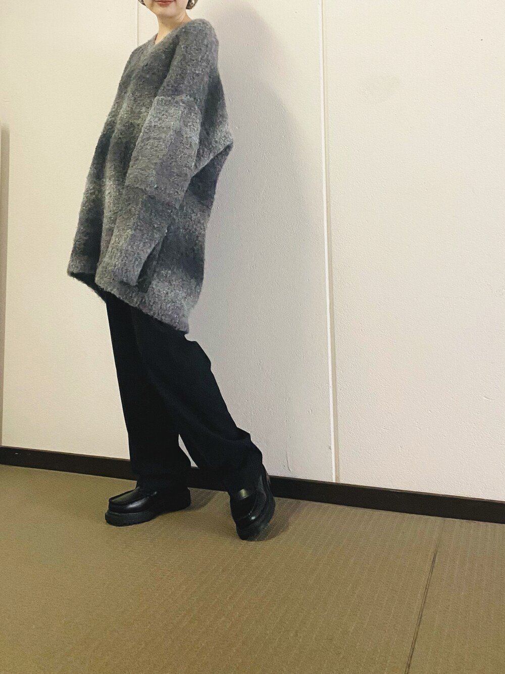 ブラック系のニット/セーター、ベージュ系のその他パンツ、ブラック系のブーツを着用したレディースの秋コーディネートの3枚目の写真