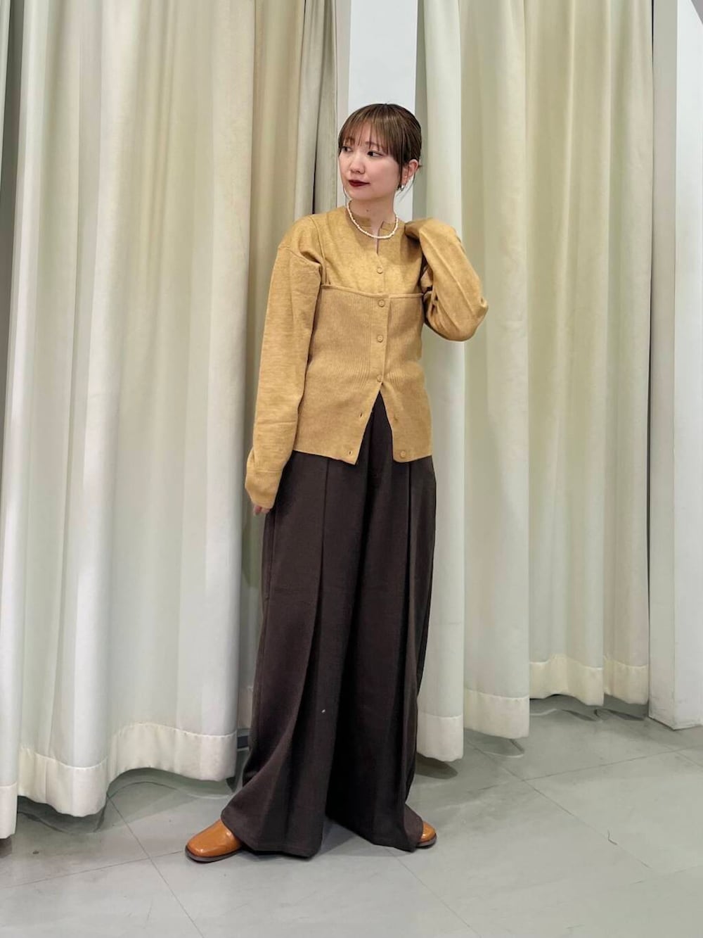 イエロー系のその他シューズ、ベージュ系のカーディガン/ボレロ、ブラウン系のその他パンツを着用したレディースの冬コーディネートの4枚目の写真