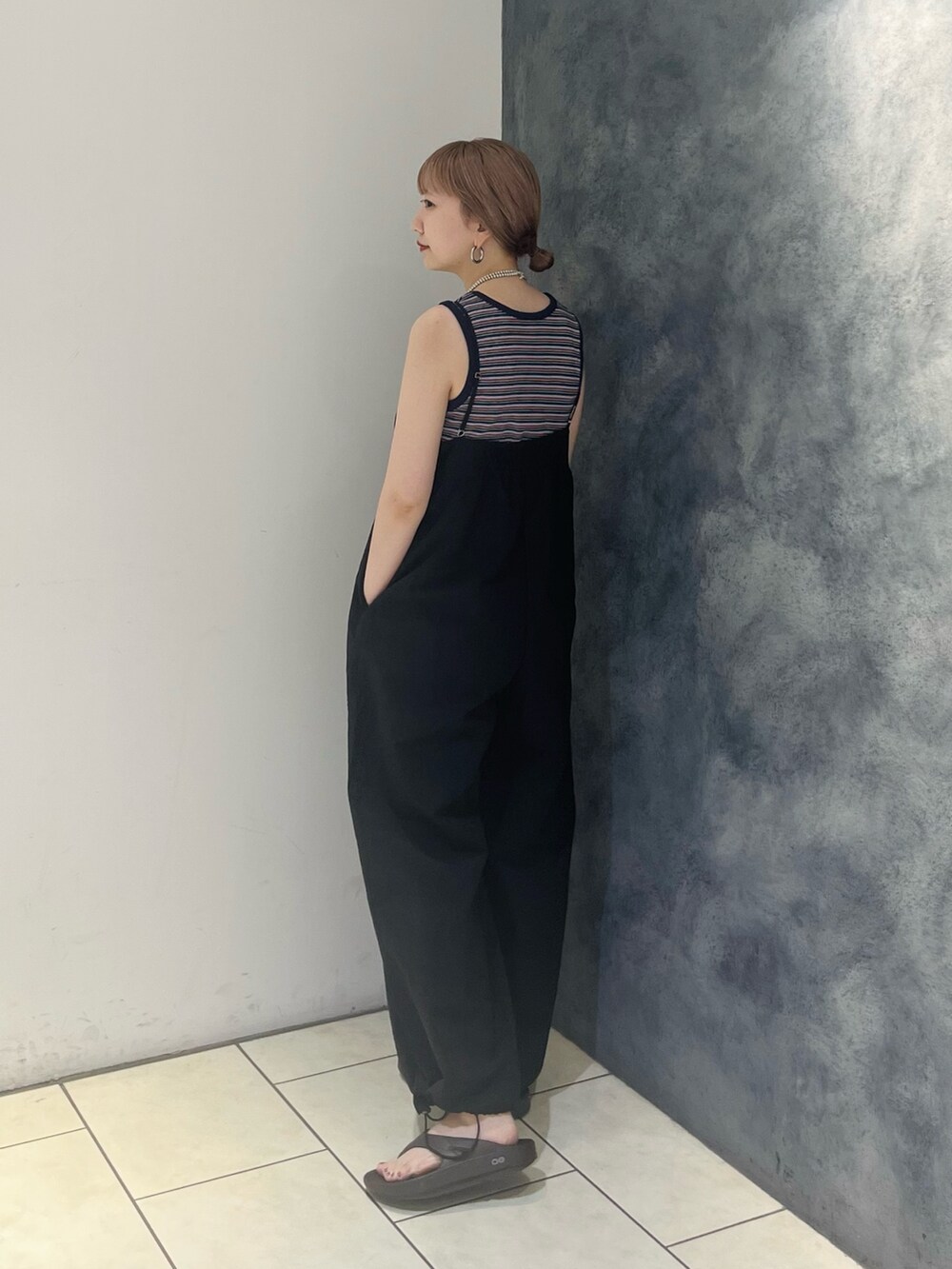 ブルー系のタンクトップ、ブラック系のサロペット/オーバーオール、シルバー系のネックレスを着用したレディースの夏コーディネートの2枚目の写真