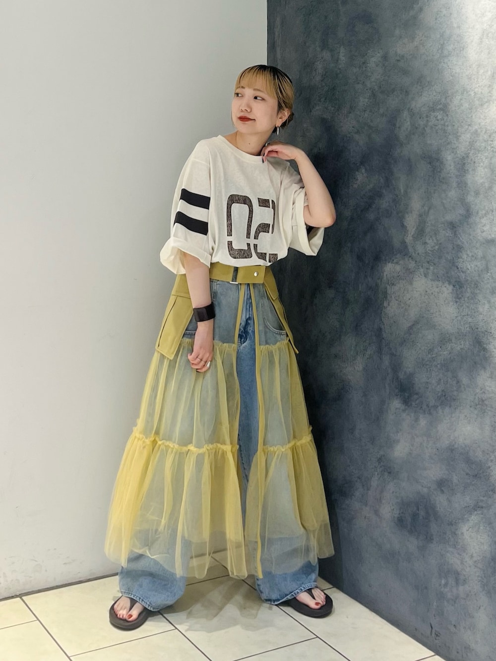 ホワイト系のTシャツ/カットソー、ベージュ系のスカート、ブルー系のデニムパンツを着用したレディースの夏コーディネートの2枚目の写真