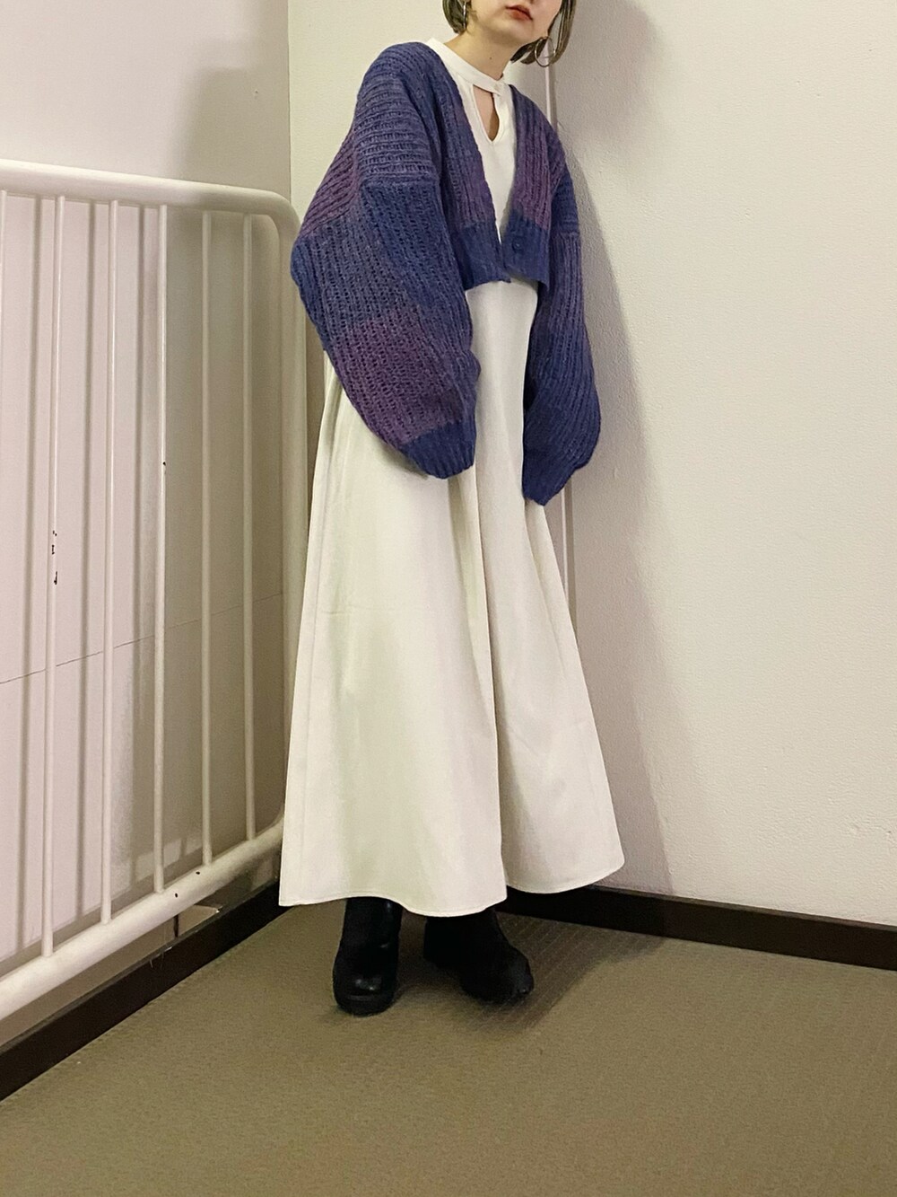 グリーン系のワンピース、パープル系のカーディガン/ボレロを着用したレディースの秋コーディネートの3枚目の写真