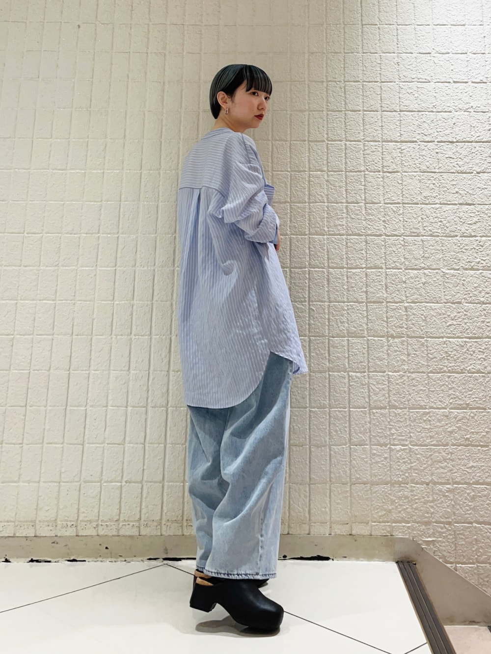 パープル系のシャツ/ブラウス、ブルー系のデニムパンツ、ブラック系のサンダルを着用したレディースの春コーディネートの3枚目の写真