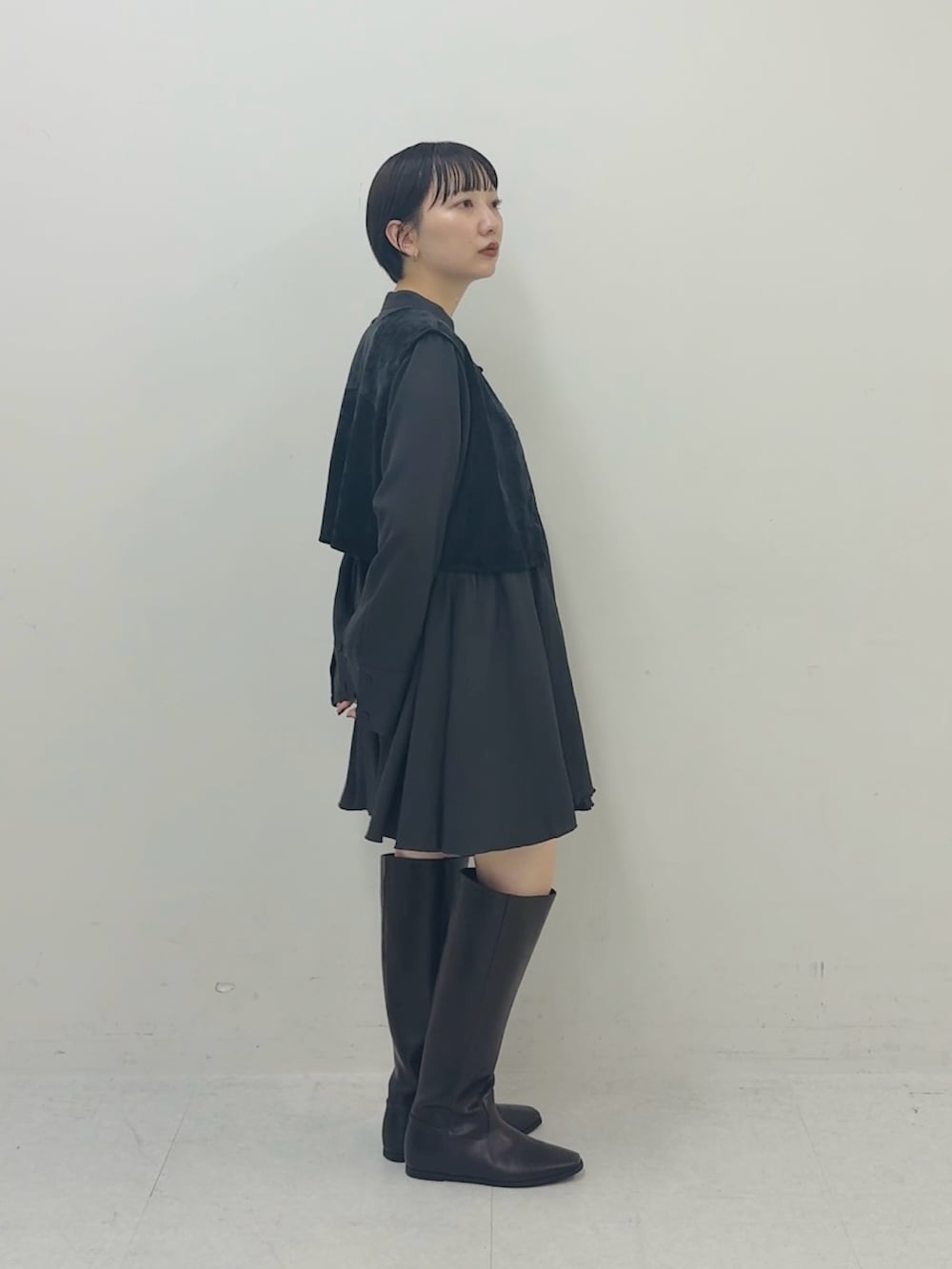グレー系のワンピース、ブラウン系のブーツを着用したレディースの秋コーディネートの2枚目の写真