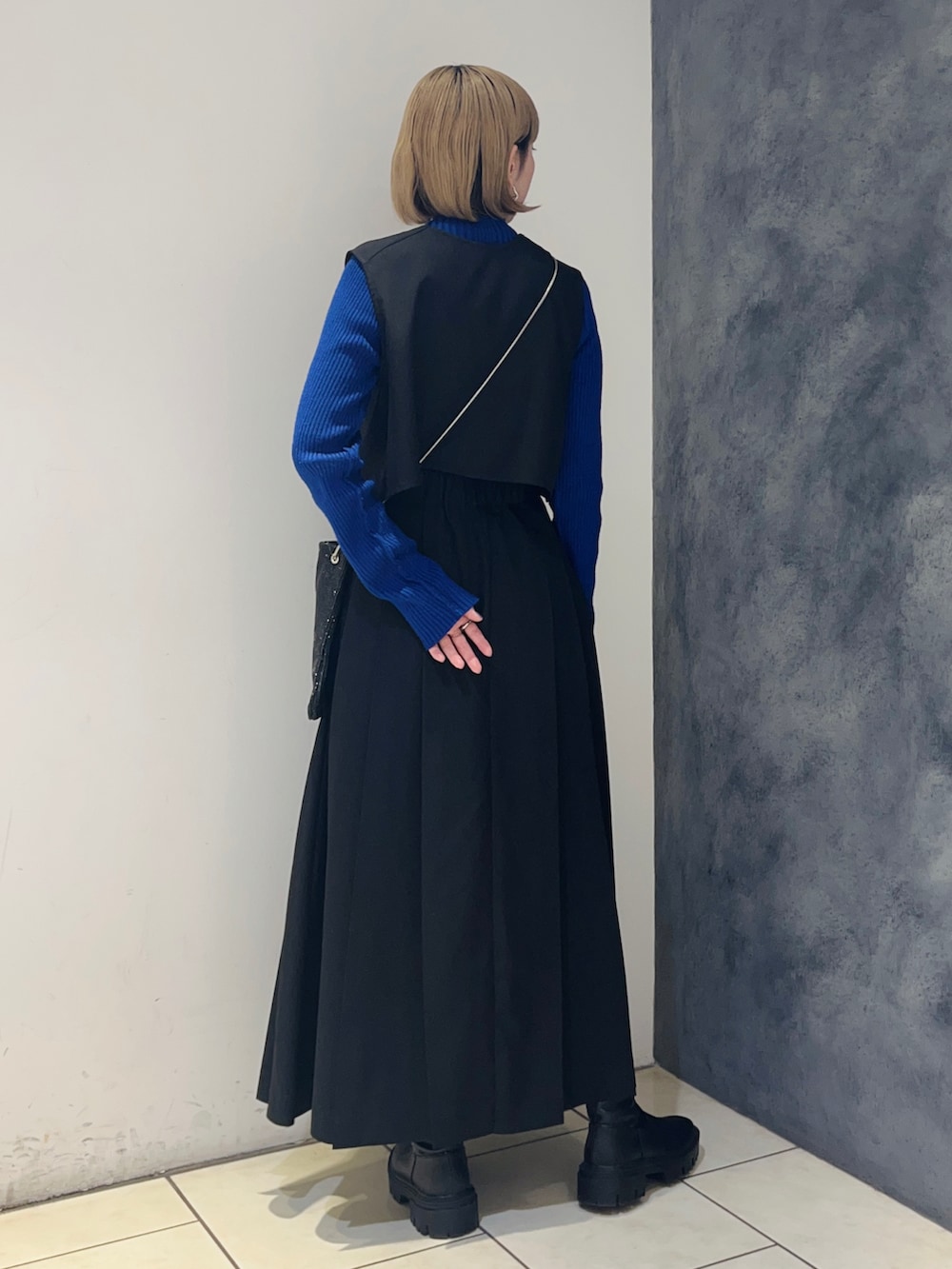 ブラック系のワンピース、ブルー系のニット/セーター、シルバー系のショルダーバッグを着用したレディースの冬コーディネートの4枚目の写真