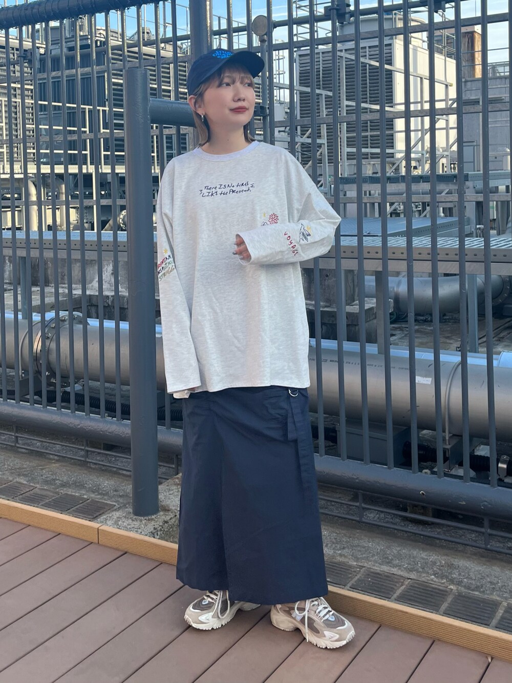 グレー系のTシャツ/カットソー、ホワイト系のスカートを着用したレディースの春コーディネートの2枚目の写真