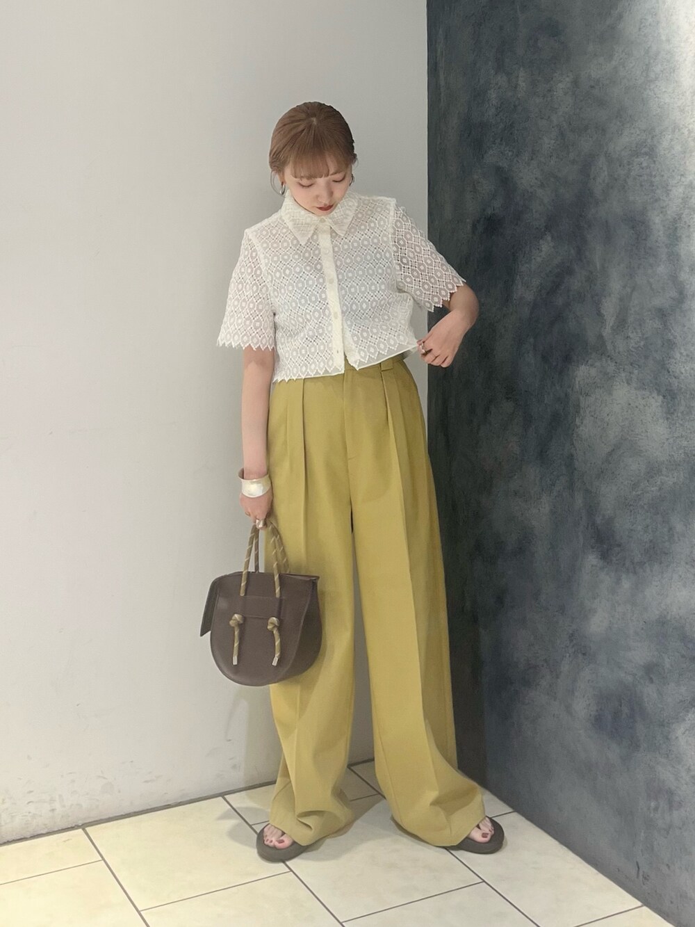 ベージュ系のその他パンツ、ホワイト系のシャツ/ブラウス、ブラウン系のハンドバッグを着用したレディースの夏コーディネートの2枚目の写真