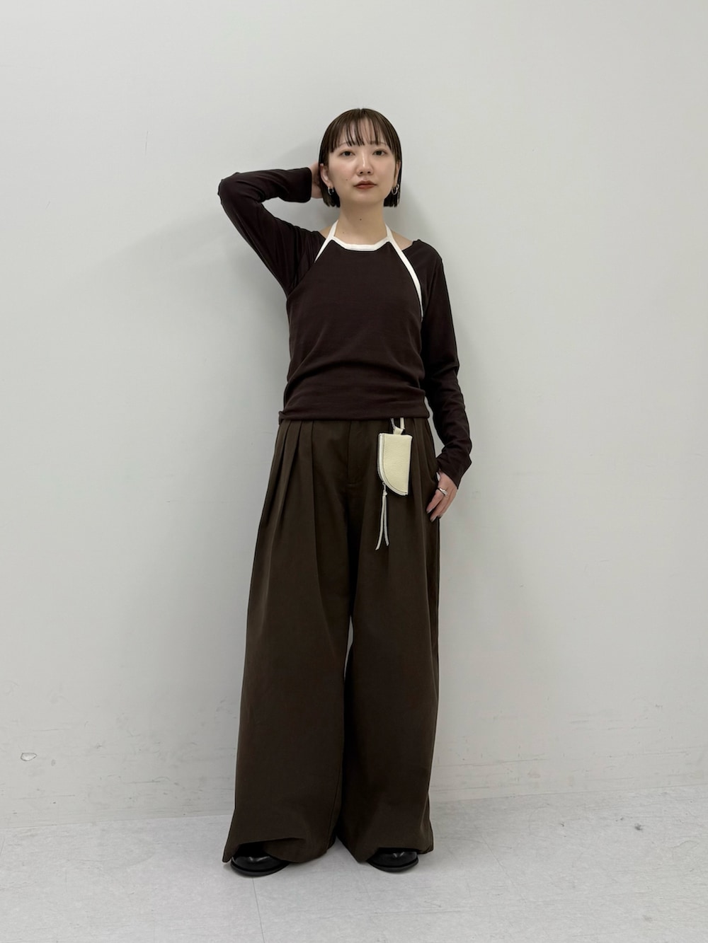 ブラウン系のTシャツ/カットソー、ホワイト系のキーホルダーを着用したレディースの冬コーディネートの2枚目の写真