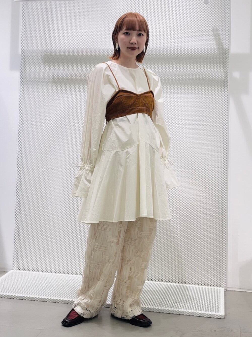 ホワイト系のワンピース、ブラウン系のベスト、ホワイト系のその他パンツを着用したレディースの春コーディネートの2枚目の写真