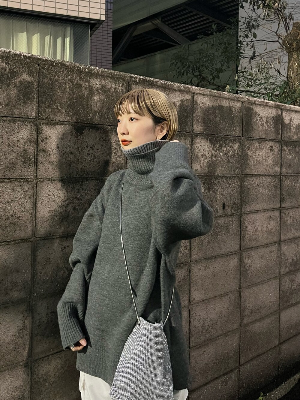 ホワイト系のカーゴパンツ、ブラック系のブーツ、シルバー系のショルダーバッグを着用したレディースの冬コーディネートの5枚目の写真