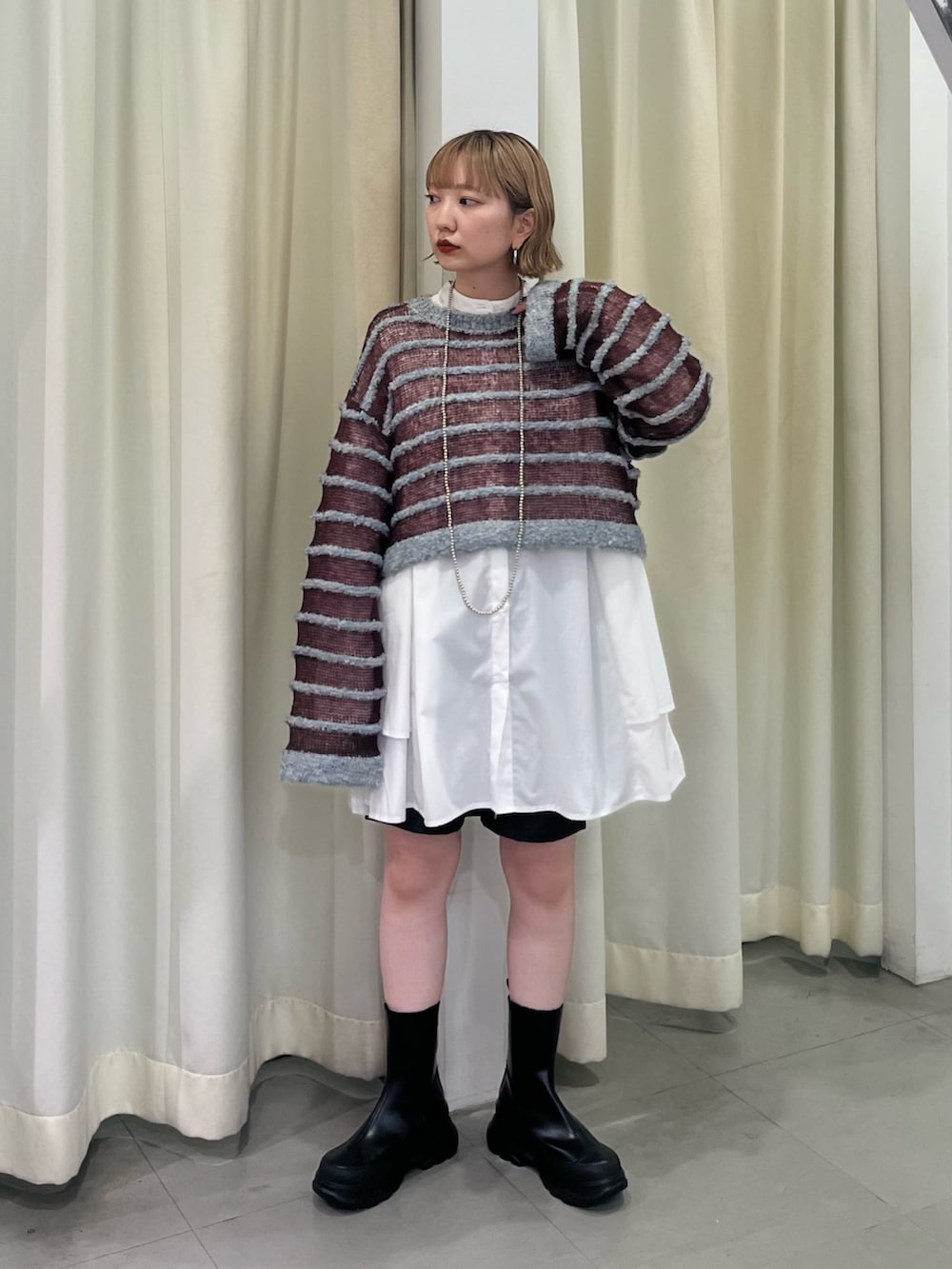 ブルー系のニット/セーター、ホワイト系のワンピース、ブラック系のブーツを着用したレディースの秋コーディネートの2枚目の写真