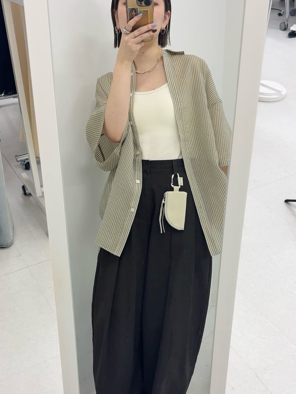 グリーン系のシャツ/ブラウス、ホワイト系のキーホルダーを着用したレディースの春コーディネートの4枚目の写真