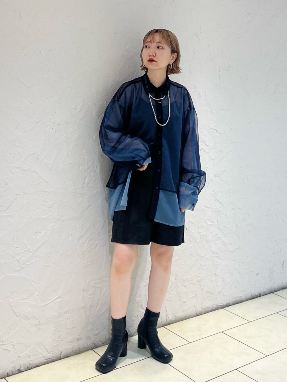 ブルー系のシャツ/ブラウス、ブラック系のその他パンツ、ブラック系のブーツを着用したレディースの秋コーディネートの2枚目の写真