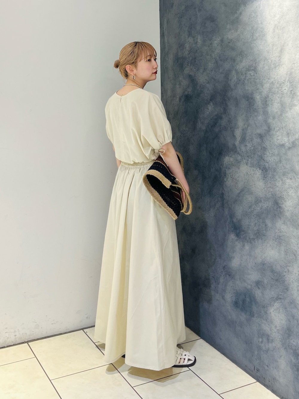 オレンジ系のワンピース、ホワイト系のサンダルを着用したレディースの夏コーディネートの2枚目の写真