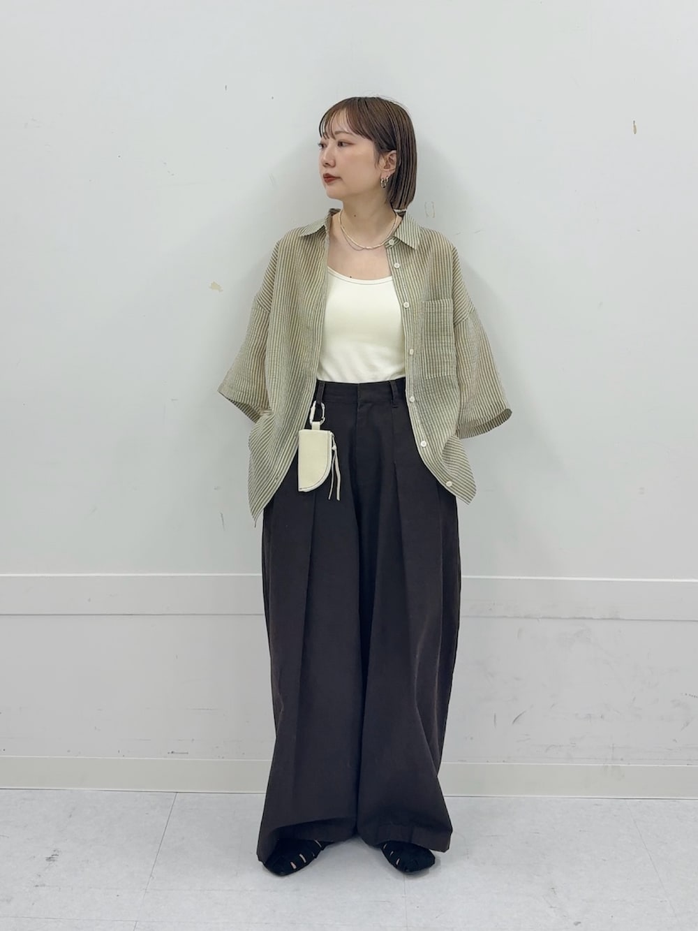 グリーン系のシャツ/ブラウス、ホワイト系のキーホルダーを着用したレディースの春コーディネートの2枚目の写真